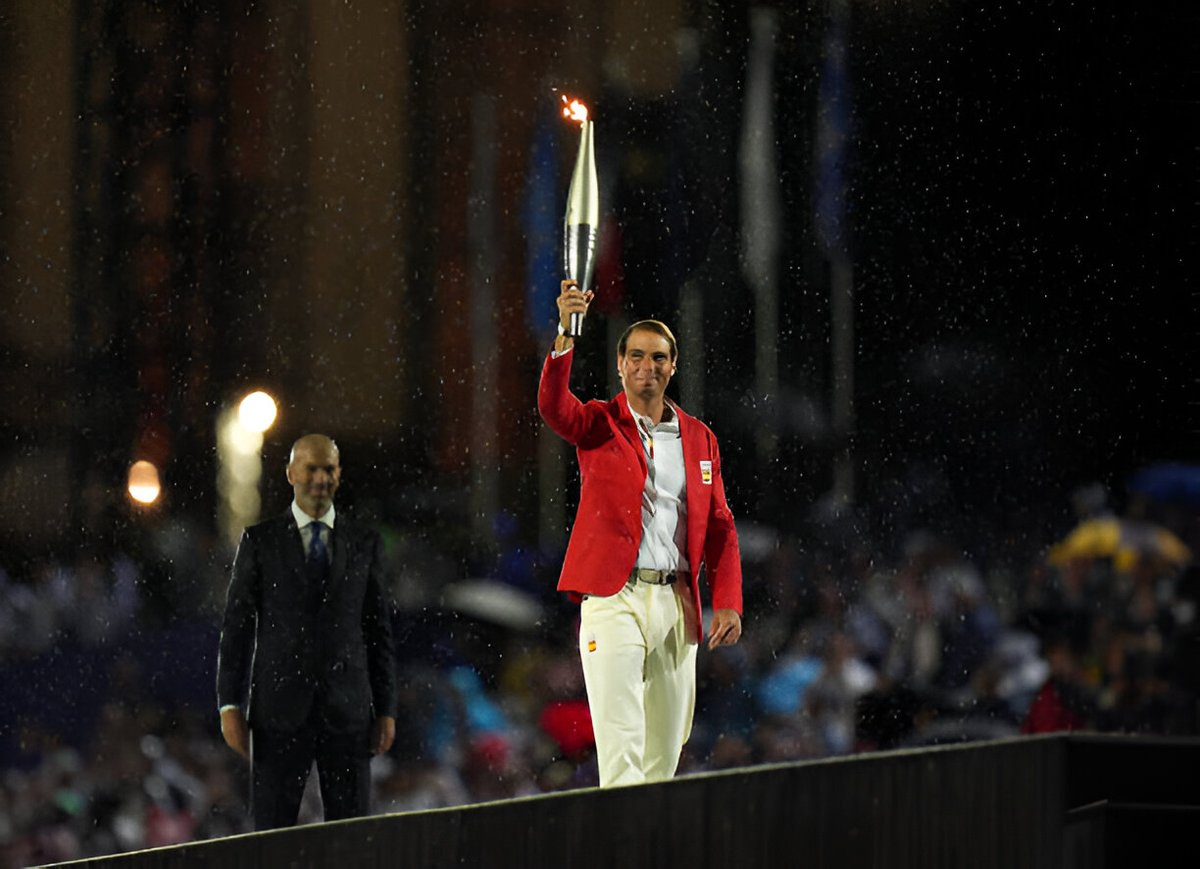 Rafael Nadal carries the Olympic flame at Paris 2024.